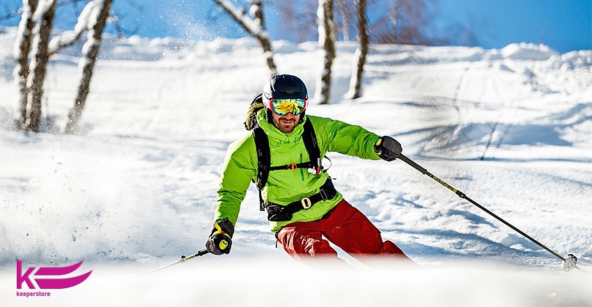 Парень спускается с горы на лыжах в горнолыжном шлеме